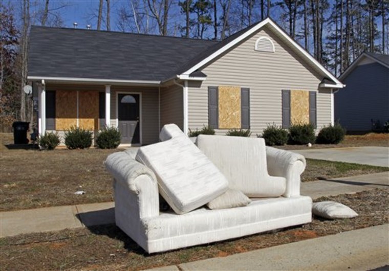 ** ADVANCE FOR USE SUNDAY, MARCH 27, 2011 AND THEREAFTER ** This Tuesday, Feb. 15, 2011 picture shows a discarded sofa in front of an abandoned house in the Windy Ridge subdivision of Charlotte, N.C. Many people sought the American Dream in starter homes here. But in this and a neighboring subdivision is a bitter lesson in how the mortgage disaster of the last few years came about, and the story of the gambles and errors that pushed the economy, and neighborhoods like this, over a cliff. (AP Photo/Bob Leverone)